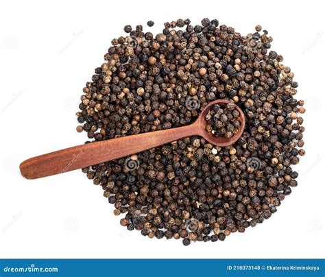 Granos de pimienta negra sobre una cuchara de madera