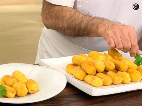 Croquetas doradas recién fritas sobre papel absorbente