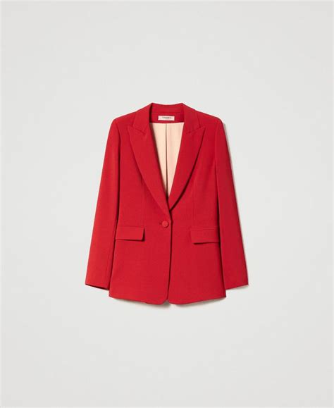 Mujer vistiendo un blazer crepé rojo en un entorno urbano