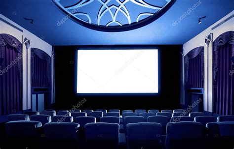 Interior de un cine con una pantalla grande y asientos cómodos