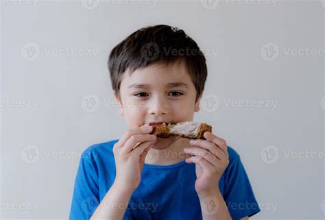 Niño comiendo un pancho a la parrilla