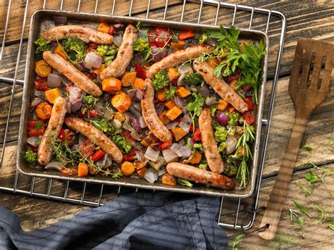 Salchichas al horno con una variedad de verduras asadas