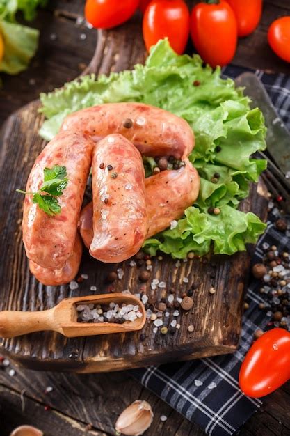 Tabla de corte con salchichas, hierbas frescas y limón