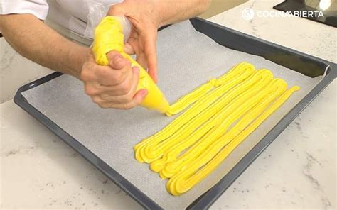 Pasta choux en manga pastelera sobre bandeja de horno
