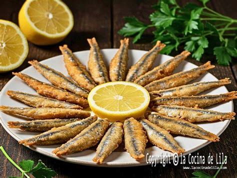 Plato de boquerones en adobo fritos servidos con limón