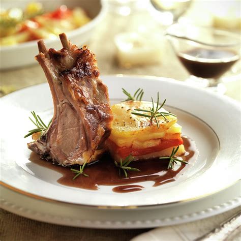 Plato de carré de cordero servido con guarnición