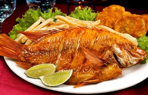 Plato de mojarra frita servida con limón y ensalada