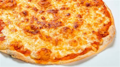 Primer plano de una pizza artesanal de masa fina con ingredientes frescos
