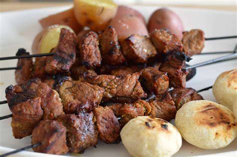 Plato de chuzos de pollo con acompañamientos colombianos