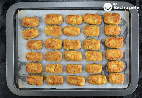 Croquetas de coliflor recién formadas en una bandeja para hornear