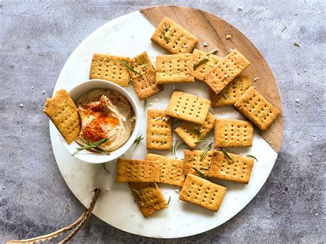 Galletas crackers sin gluten en un plato con queso y embutidos