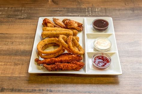 Variedad de entrantes: aros de cebolla, alitas de pollo y nachos
