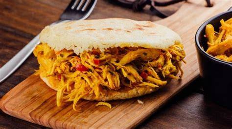 Una arepa rellena de pollo desmechado.