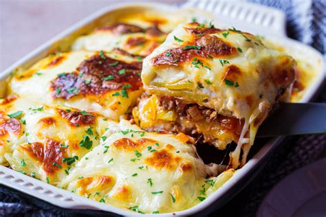 Montaje de lasaña de patata con capas de carne y bechamel