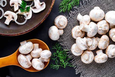 Champiñones frescos y ajos cortados en una sartén