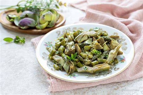 Champiñones, alcachofas y espárragos cocinándose en una sartén