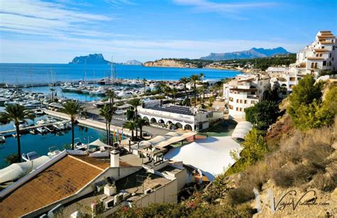 Vista panorámica del puerto de Moraira con barcos y restaurantes.