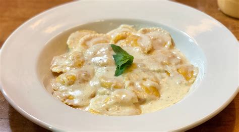 Ravioles de jamón y queso servidos con salsa