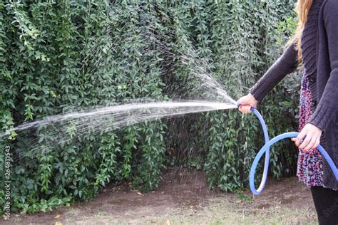Persona regando plantas con un fertilizante casero