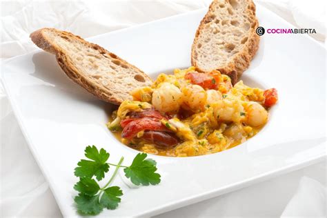 Plato de revuelto de pimientos y langostinos servido con pan tostado