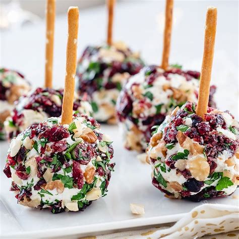 Bolitas de queso con arándanos y nueces presentadas en una fuente