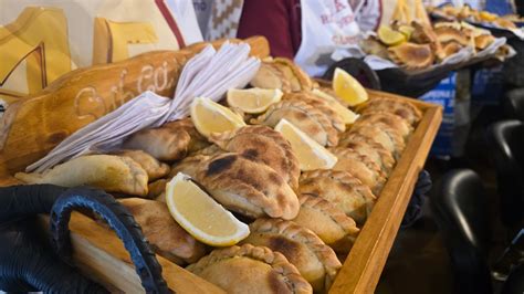 Personas celebrando el Día Nacional de la Empanada degustando diferentes tipos de empanadas