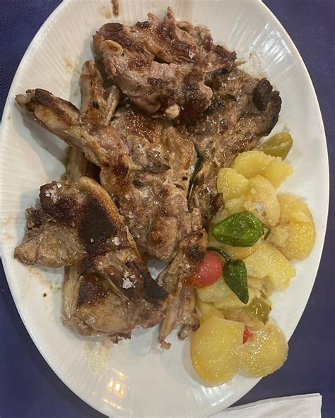 Plato de chuletillas de cordero con guarnición de patatas y pimientos