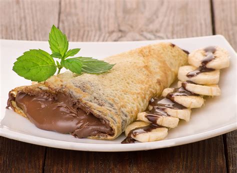 Detalle de cómo untar Nutella y colocar rodajas de plátano en la crepe