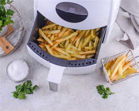 Patatas y cebolla dispuestas en la cesta de la freidora de aire