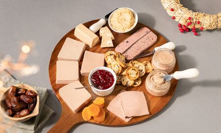 Detalle de tabla de patés con frutos secos, uvas y panecillos variados