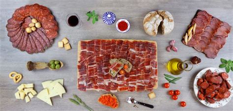 Variedad de embutidos ibéricos y quesos en una tabla de aperitivos