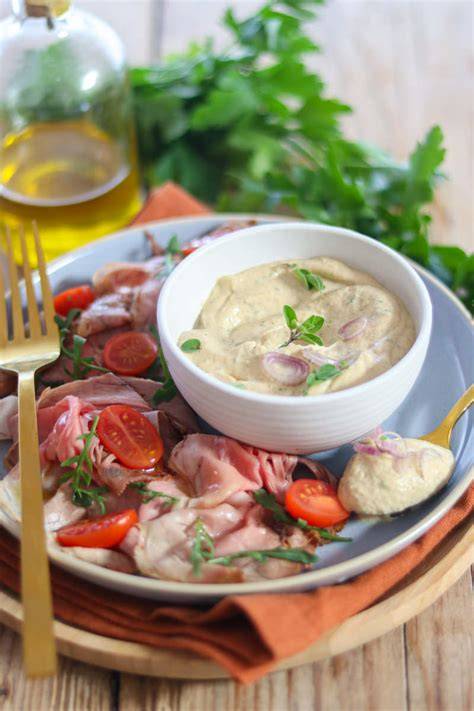 Plato de Vitello Tonnato servido con salsa tonnata y guarnición