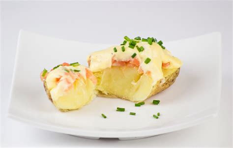 Plato terminado de patatas rellenas de salmón y salsa holandesa