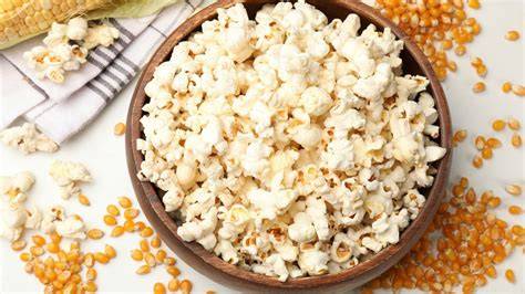 Palomitas de maíz en un bol con granos de maíz sin reventar