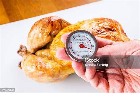 Termómetro de carne insertado en un pollo asado