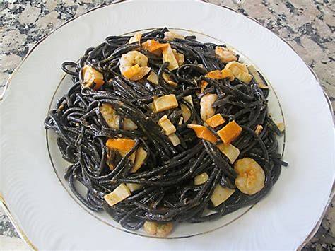 Espaguetis negros con gambas y surimi en un plato