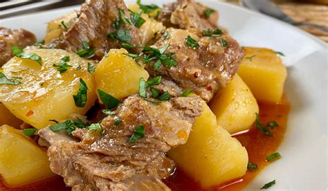 Plato servido de cazuela de patatas con costillas y almendras