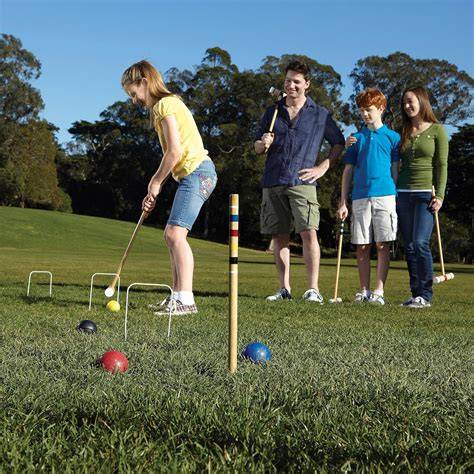 Jugadores de croquet en acción con mazos y bolas