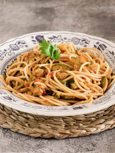 Plato de espaguetis integrales con salsa de verduras, alcaparras y aceitunas