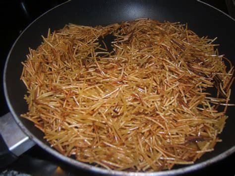 Primer plano de fideos dorados en una paellera
