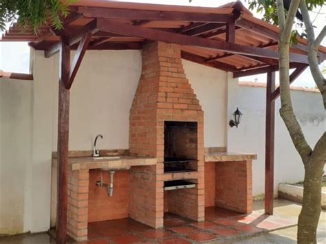 Asador de ladrillo tradicional con chimenea y techo a dos aguas
