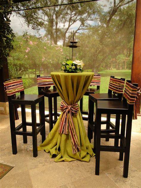 Mesa alta con mantel tostado y decoración colorida