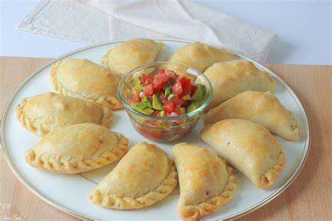 Plato de empanadas variadas servidas como tapas con acompañamientos