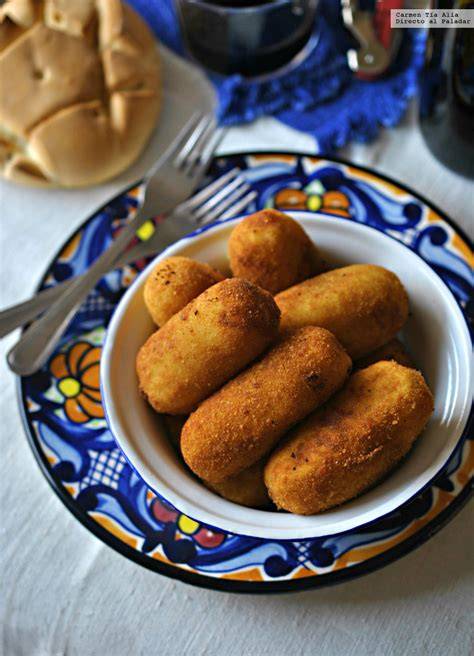 Plato de croquetas de patata rellenas de morcilla y cebolla confitada recién hechas
