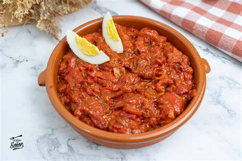 Plato de asadillo de pimiento terminado con cebolla
