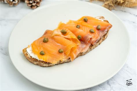 Tosta gourmet de salmón ahumado y queso brie decorada con hierbas frescas