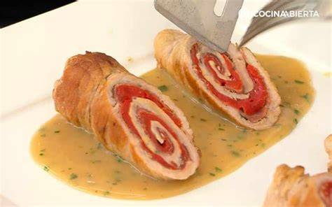 Plato de rollitos de cerdo rellenos con salsa gravy y guarnición