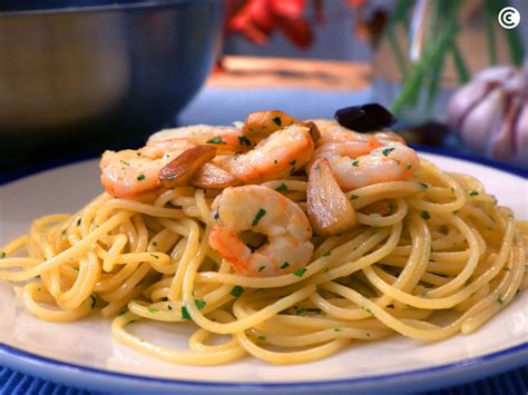 Espaguetis y gambas mezclándose en la sartén
