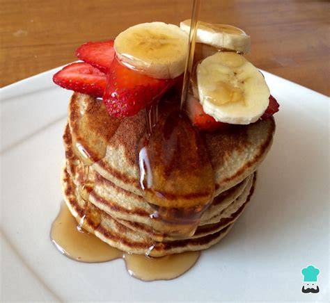 Plato de tortitas de avena y plátano con frutas frescas y sirope