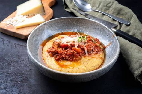 Plato de polenta servido con ragú de boletus y nueces